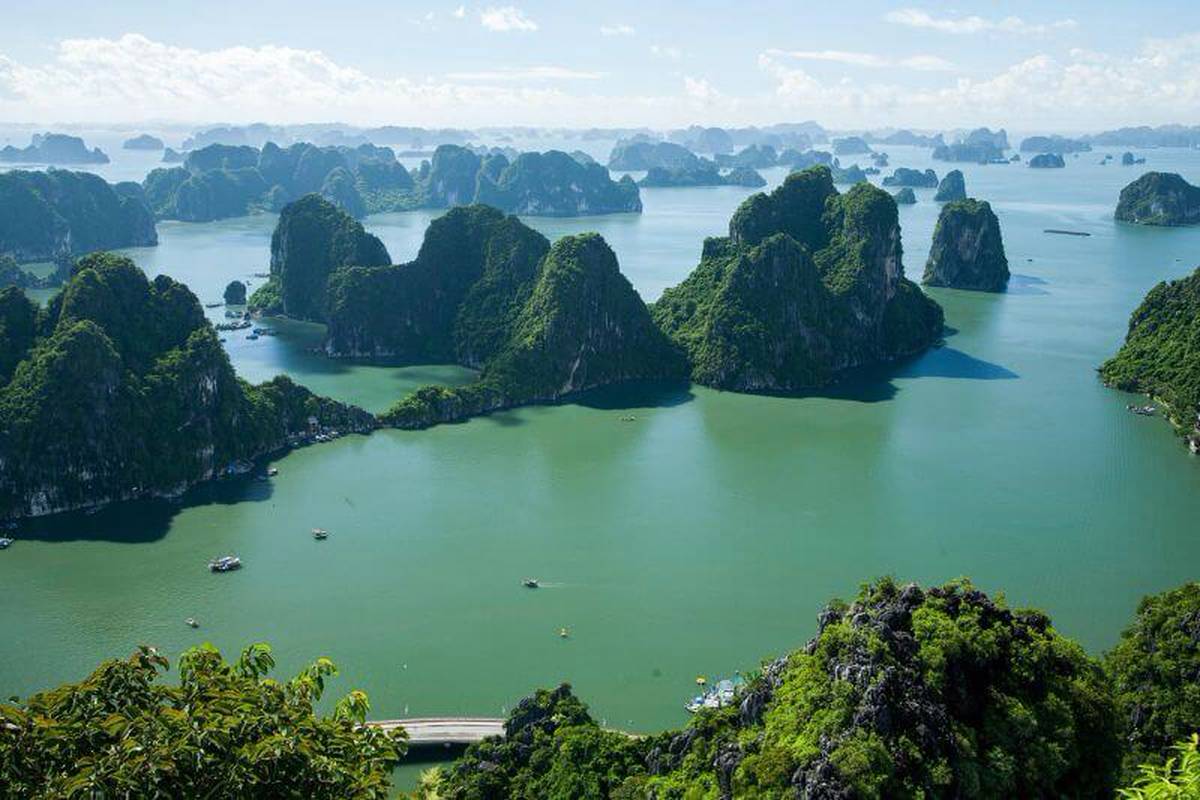 Green limestone islands rising from turquoise water on Ha Long Bay, seen from above