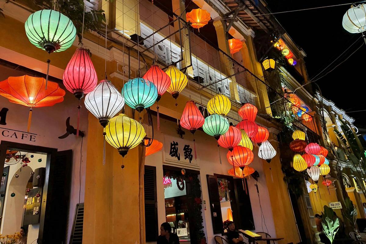 Silk lanterns glowing outside a yellow-walled shop in Hoi An Ancient Town at night