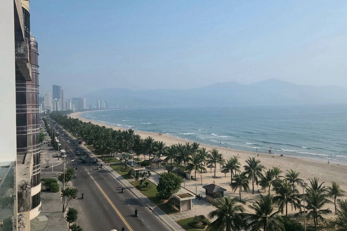 Palm trees and the long curve of My Khe Beach in Da Nang seen from above