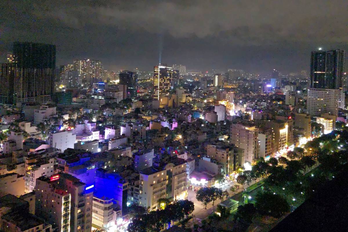 The lights of Ho Chi Minh City spreading across the skyline at night, seen from a high floor