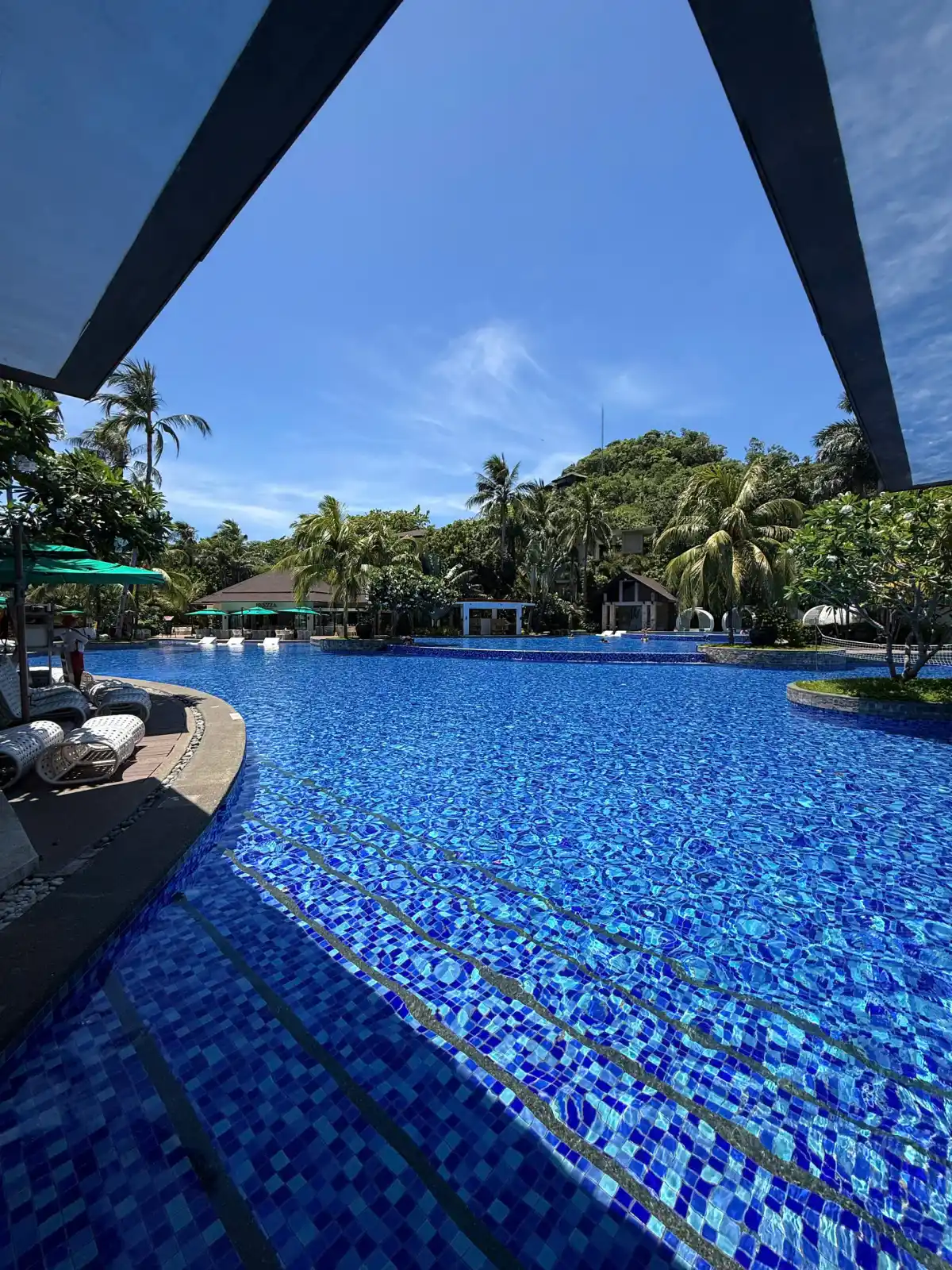 Hồ bơi lớn lát gạch xanh của Mövenpick Boracay giữa hàng dừa