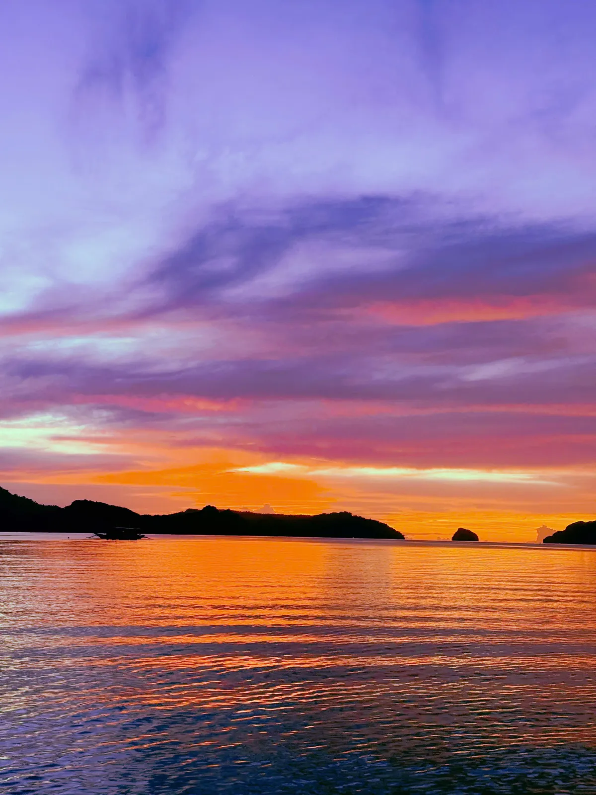 Hoàng hôn tím cam trên vịnh El Nido, đảo đá vôi in bóng