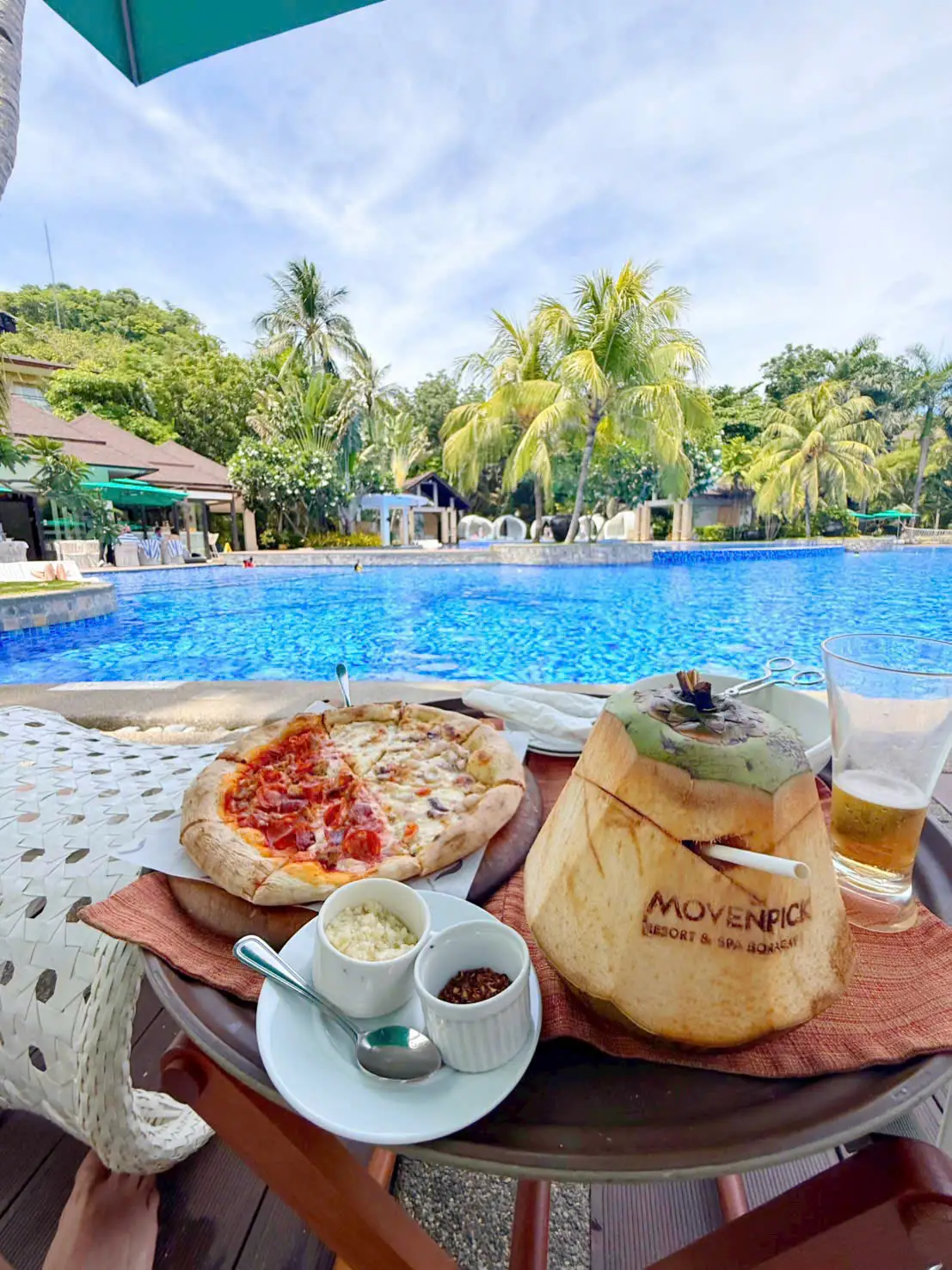Pizza và trái dừa khắc tên Mövenpick bên hồ bơi