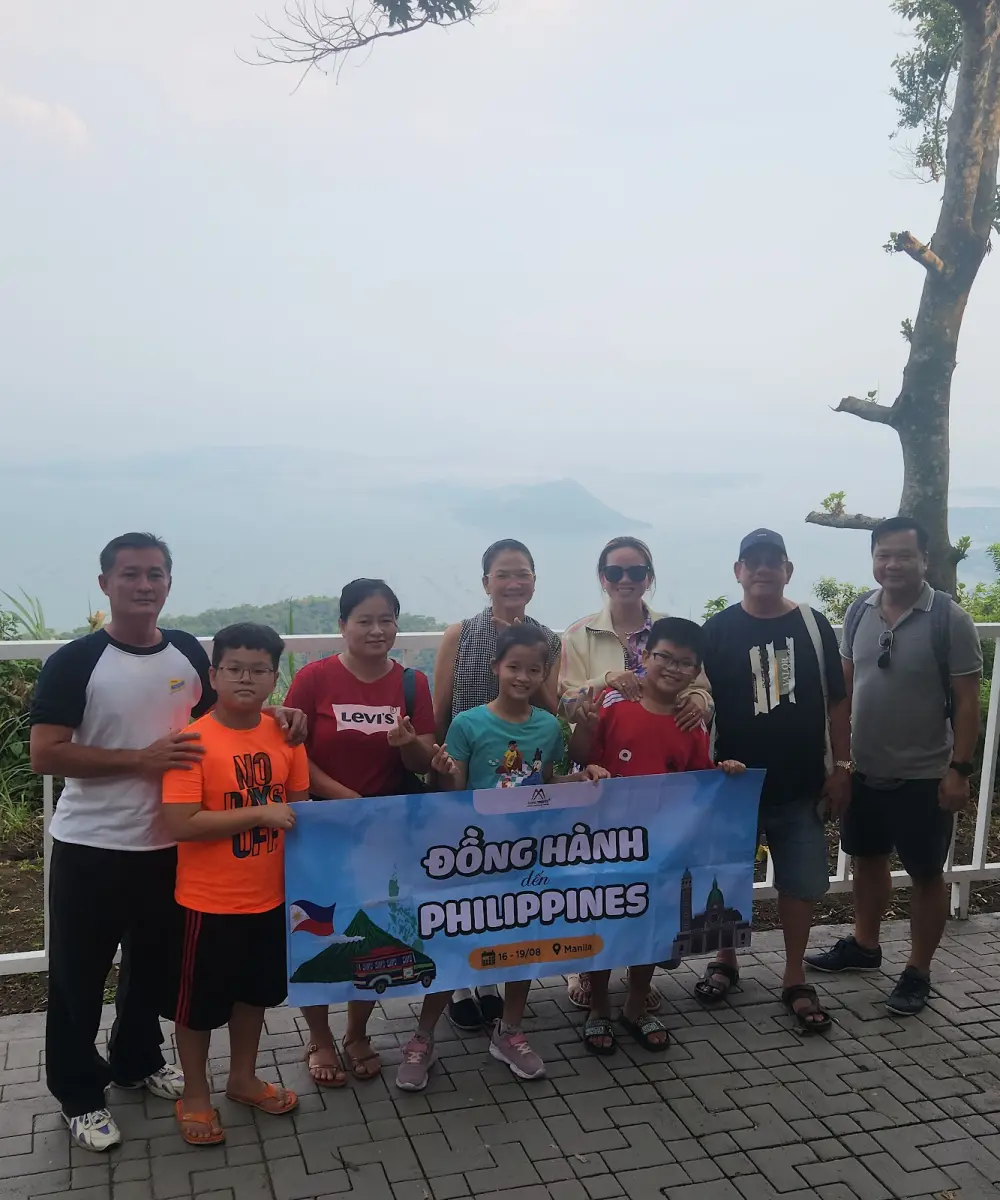 Đoàn khách Dong Thi Travel cầm băng rôn tại điểm ngắm hồ Taal, Tagaytay