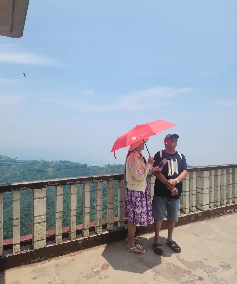 Hai khách che ô ngắm cảnh cao nguyên Tagaytay