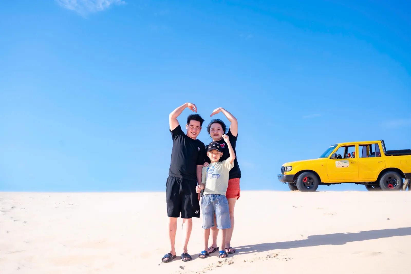 Gia đình nhân viên cùng con nhỏ trên đồi cát Bàu Trắng, cạnh xe jeep