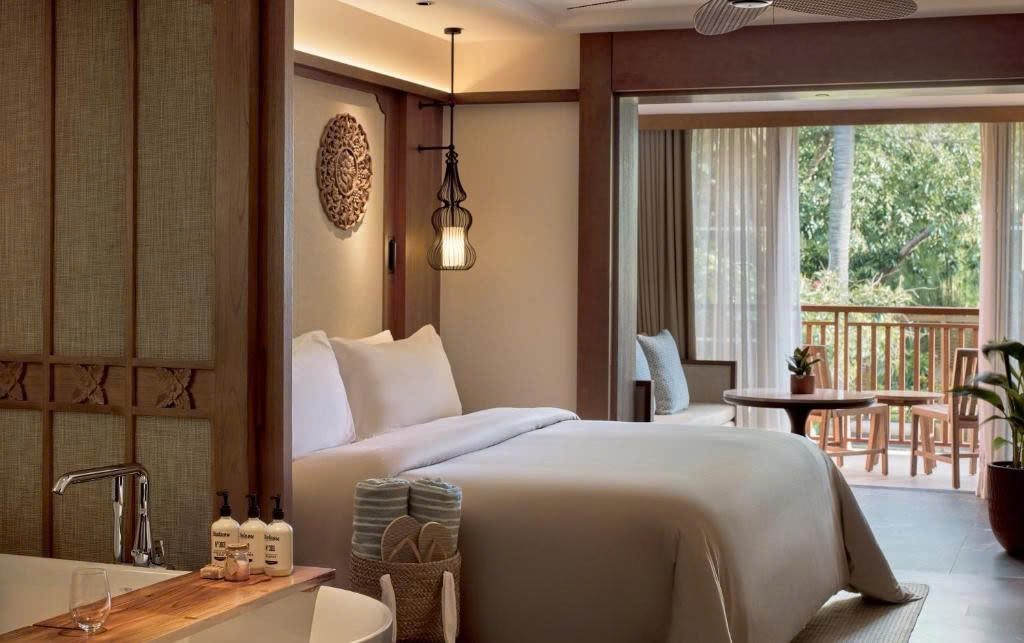 Phòng ngủ có bồn tắm và ban công ở Paradisus Bali