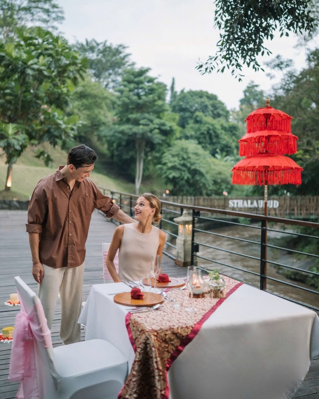 Bàn ăn trên sàn gỗ bên sông ở Sthala Ubud